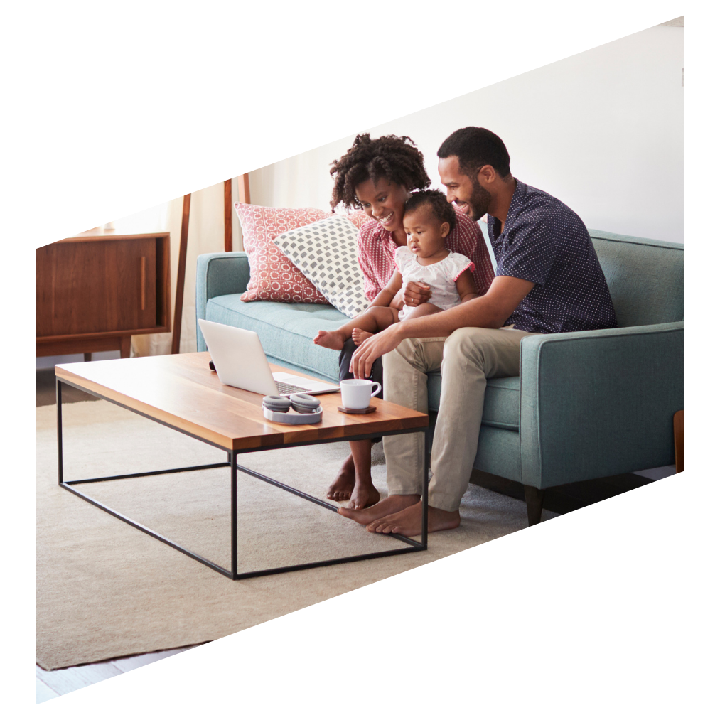 Adult couple with little girl on the couch with a laptop