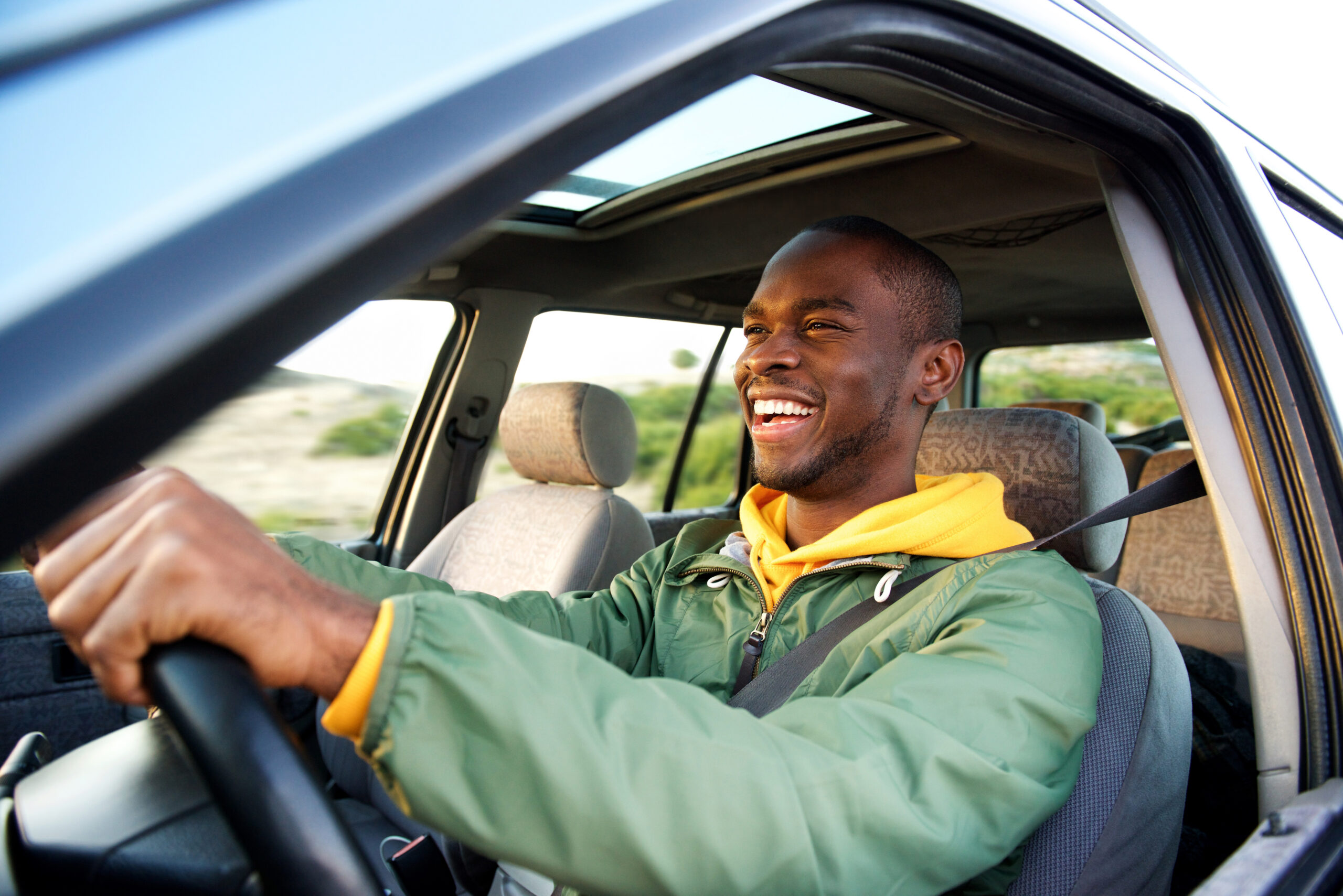 Black man happy driving a car