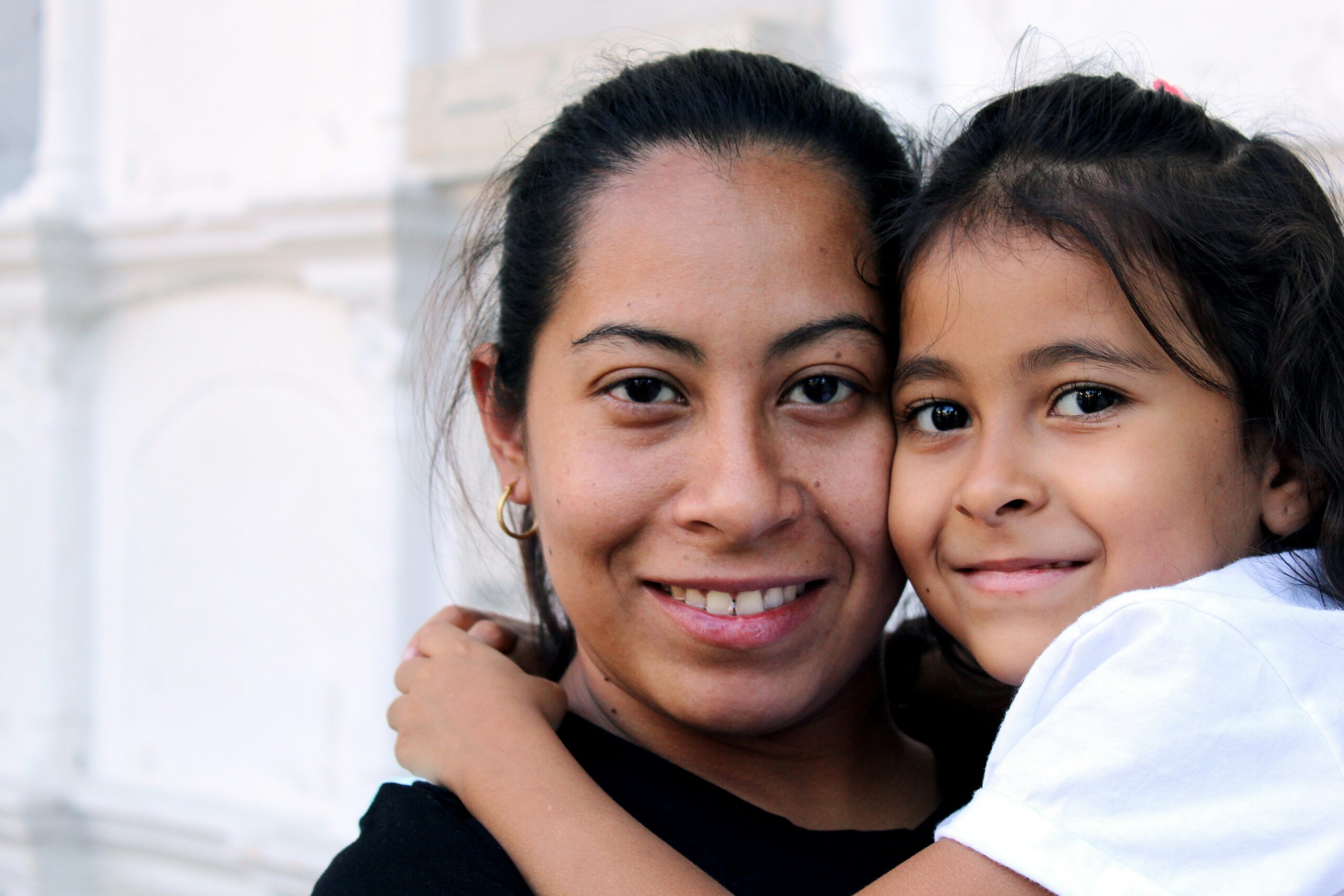 Hispanic mother holding her daughter