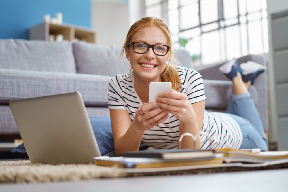 White woman using laptop on carpeted floor